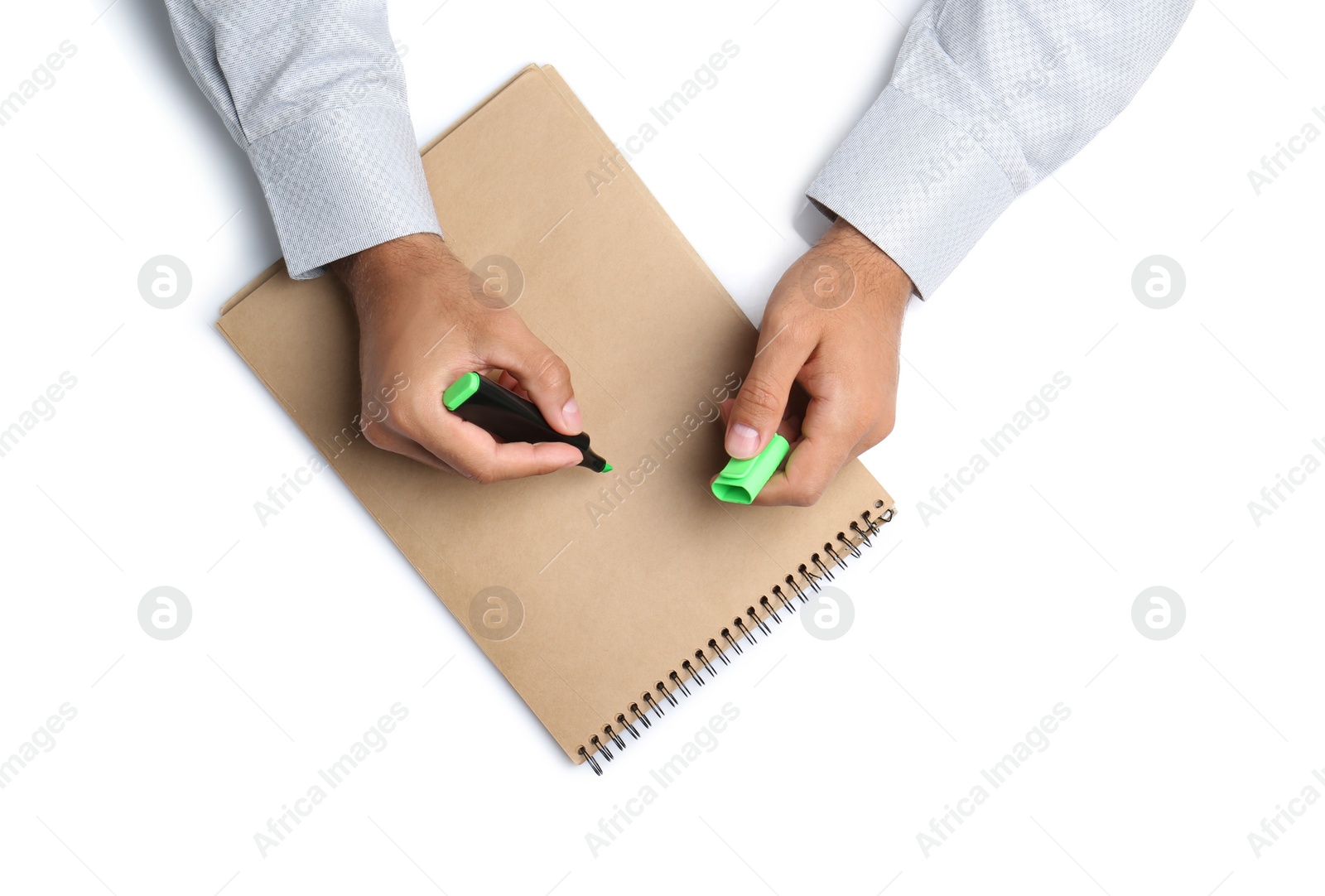 Photo of Man with highlighter and notepad on white background, top view. Closeup of hands