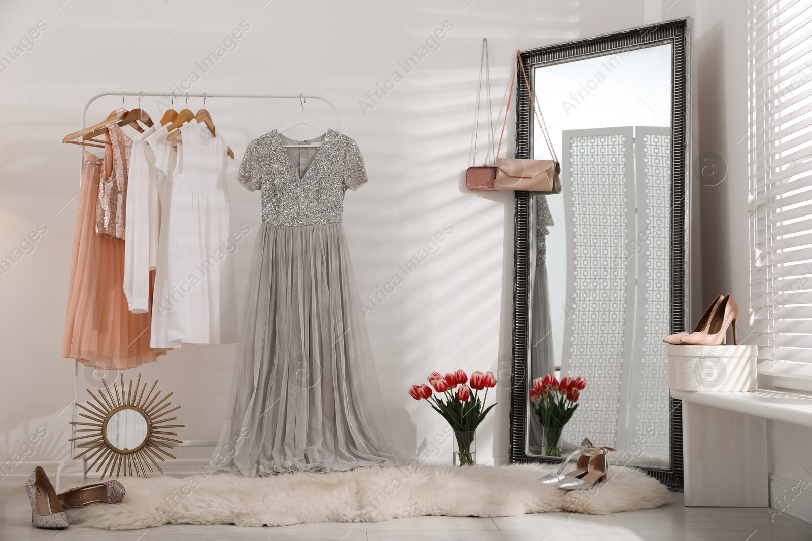 Photo of Rack with stylish women's clothes and mirror indoors. Interior design