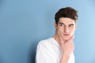 Portrait of young man with beautiful hair on color background