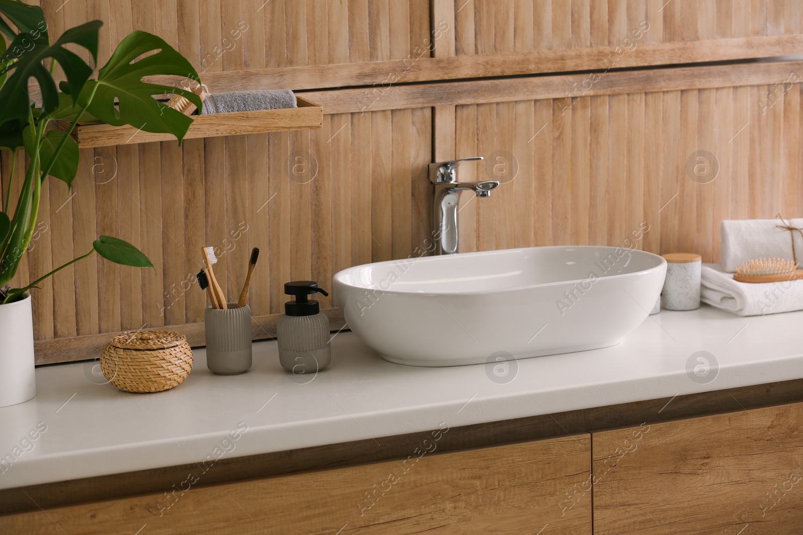 Photo of Stylish vessel sink near wooden wall in modern bathroom