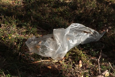 Disposable polyethylene bag on ground outdoors, above view. Recycling problem