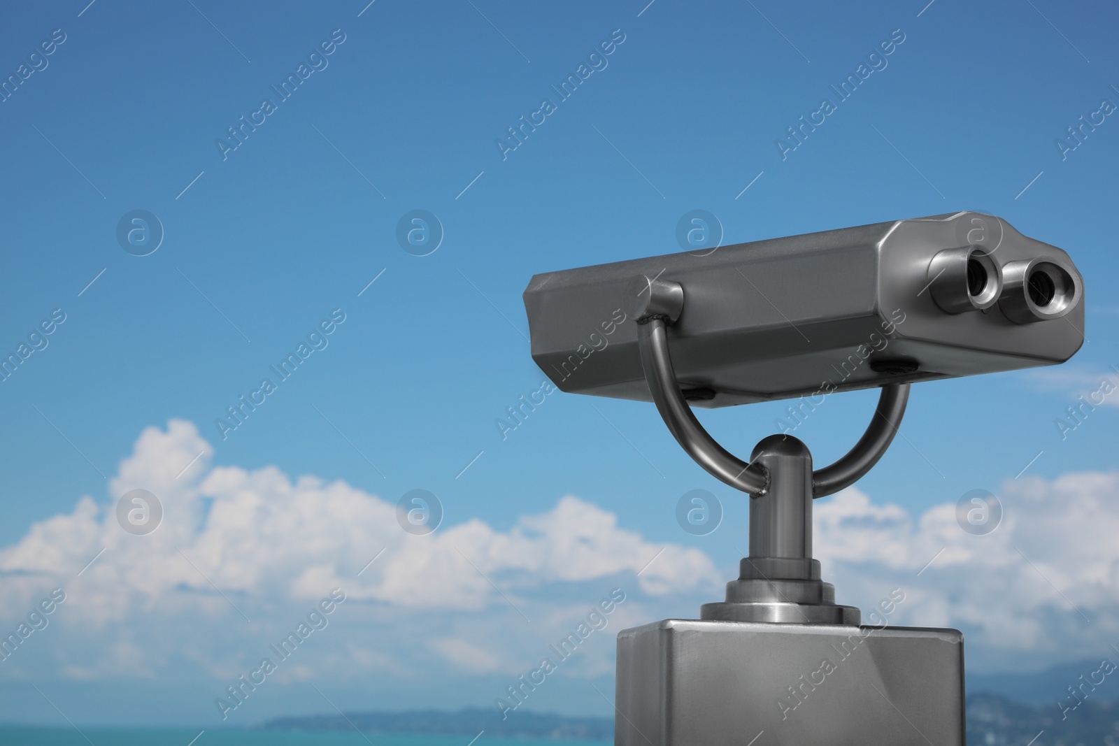 Photo of Metal tower viewer installed near sea, space for text. Mounted binoculars