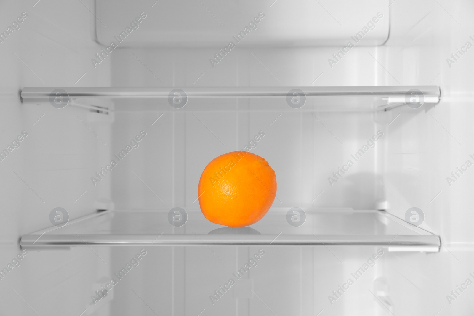 Photo of Fresh orange on shelf inside modern refrigerator