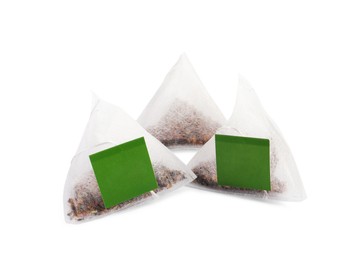 Photo of New pyramid tea bags on white background