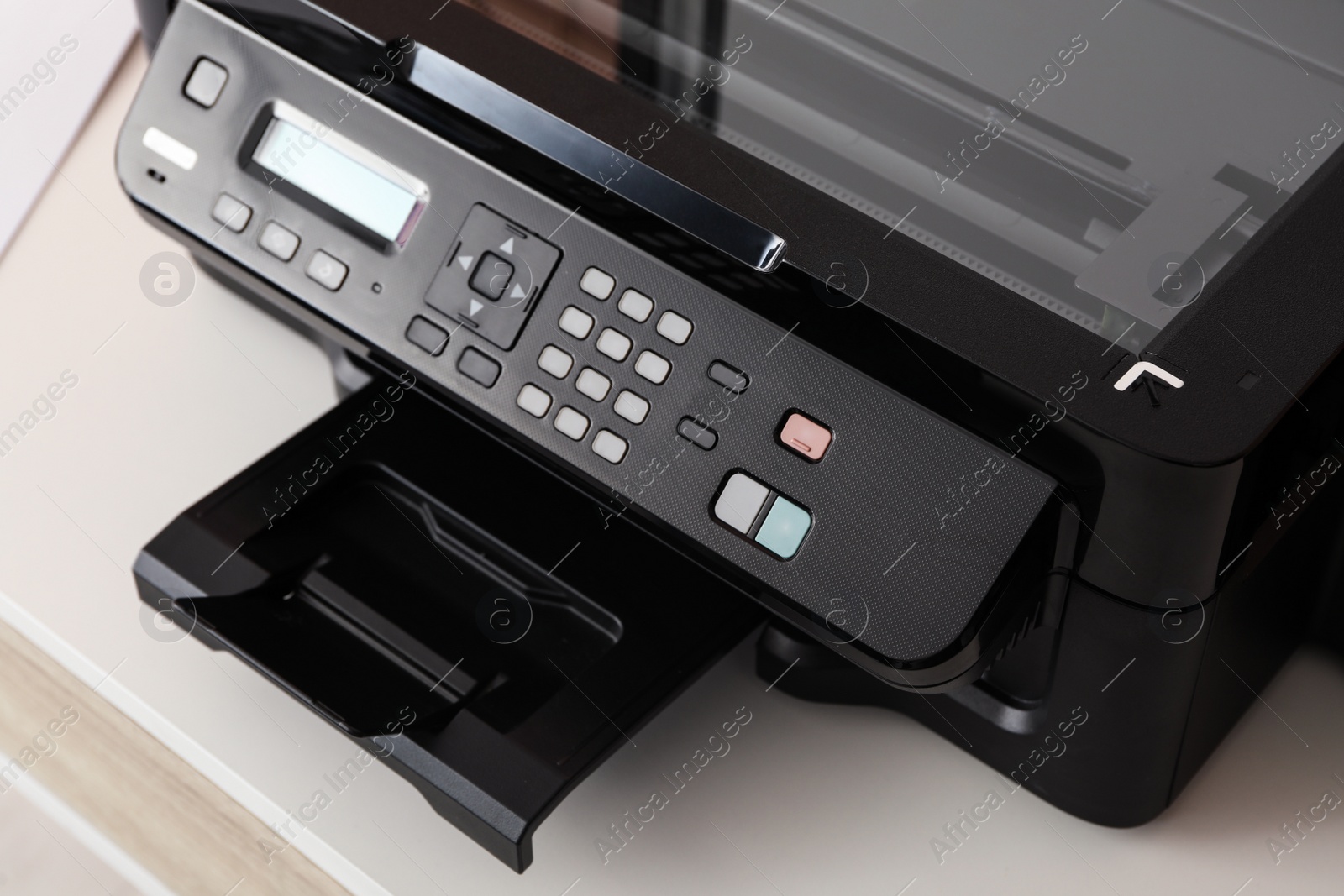 Photo of Closeup view of new modern printer with control panel on white table