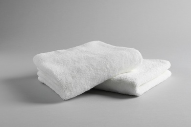 Photo of Fresh soft folded towels on light background