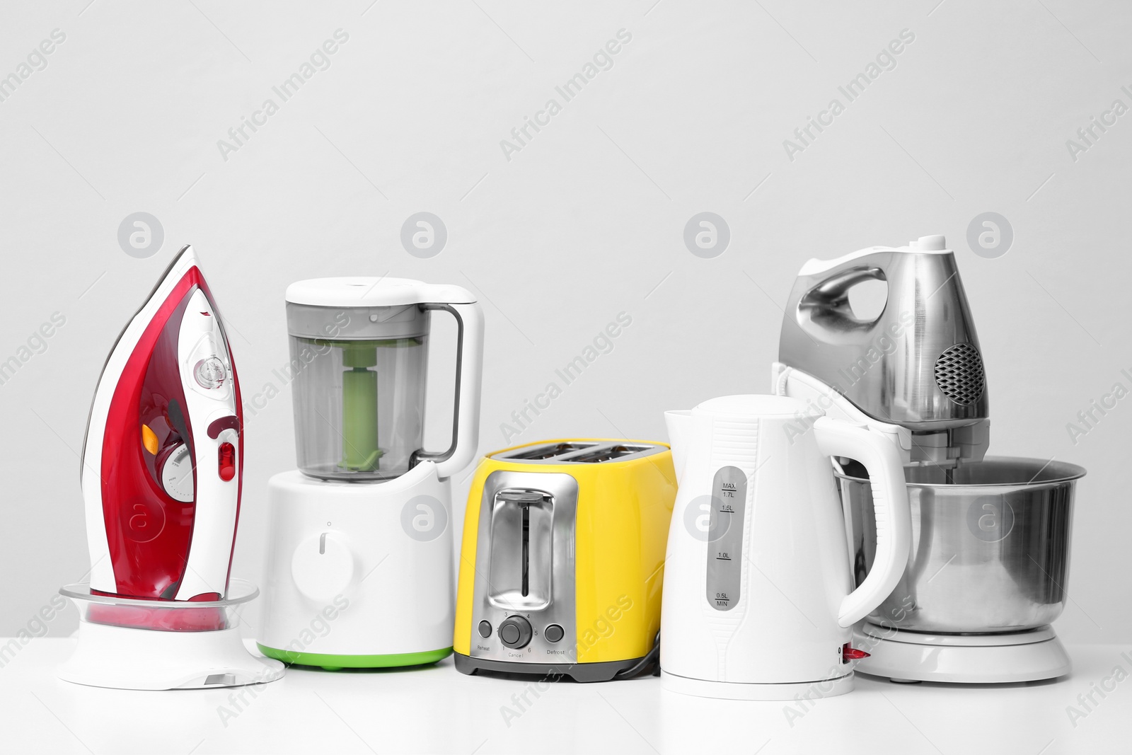 Photo of Household and kitchen appliances on table against light background. Interior element