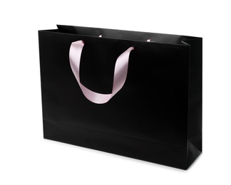 Photo of Paper shopping bag with ribbon handles on white background. Mockup for design