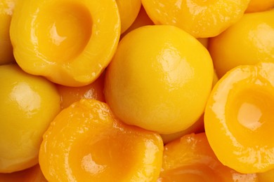 Halves of canned peaches as background, top view