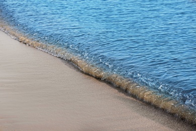 Photo of View of sea water and beach sand on sunny summer day