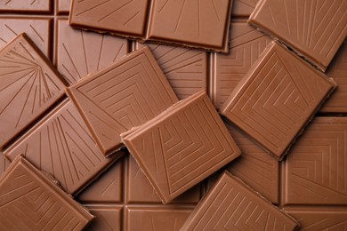 Pieces of tasty chocolate bar as background, top view