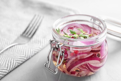 Photo of Jar of pickled onions on grey table