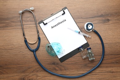 Flat lay composition of clipboard with word Anesthesia and drugs on wooden table