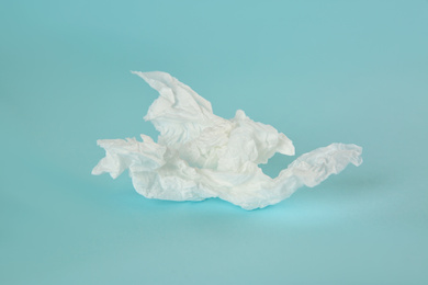 Photo of Used paper tissue on light blue background, closeup