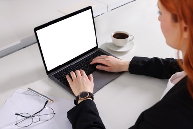 Woman working with laptop at white desk, closeup