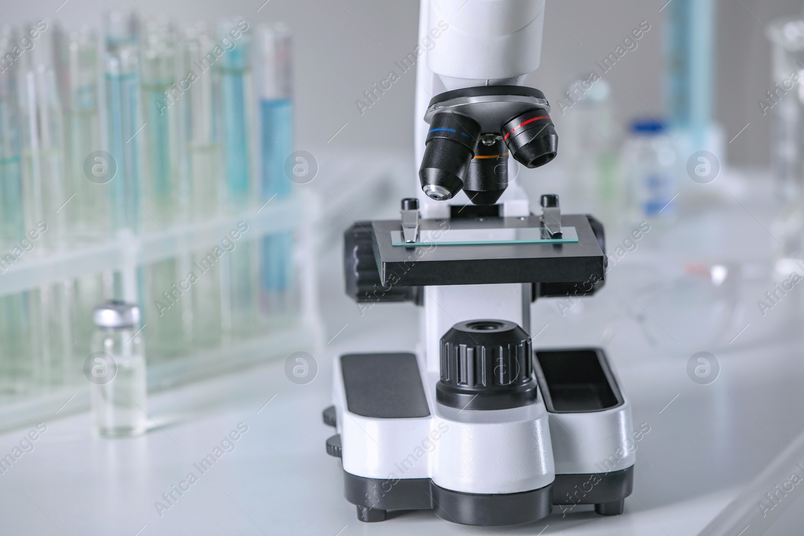 Photo of Modern medical microscope on white table in laboratory, closeup. Space for text