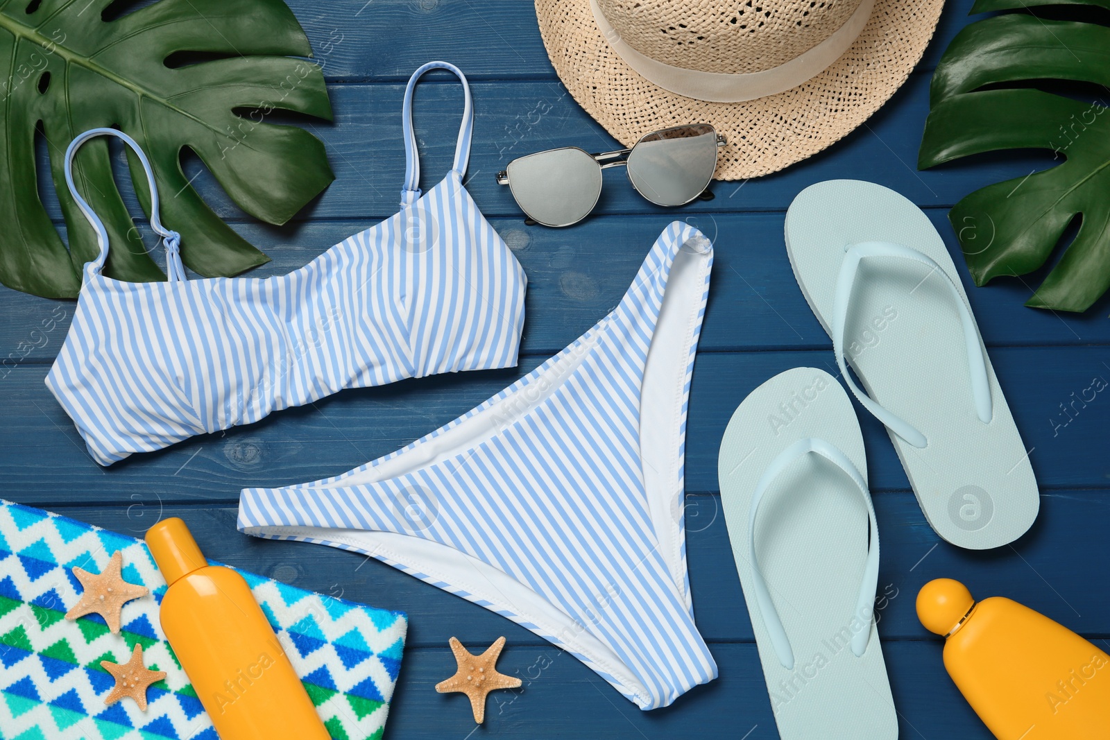 Photo of Flat lay composition with beach accessories on blue wooden background