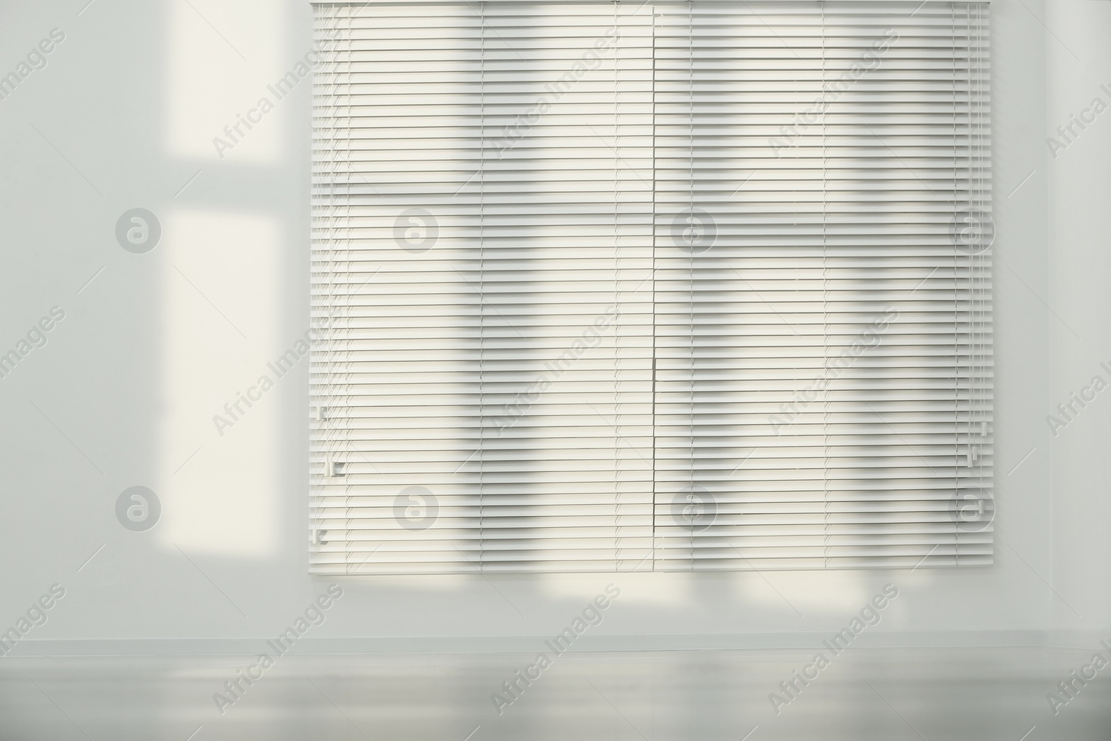 Photo of Light and shadows from window on wall indoors