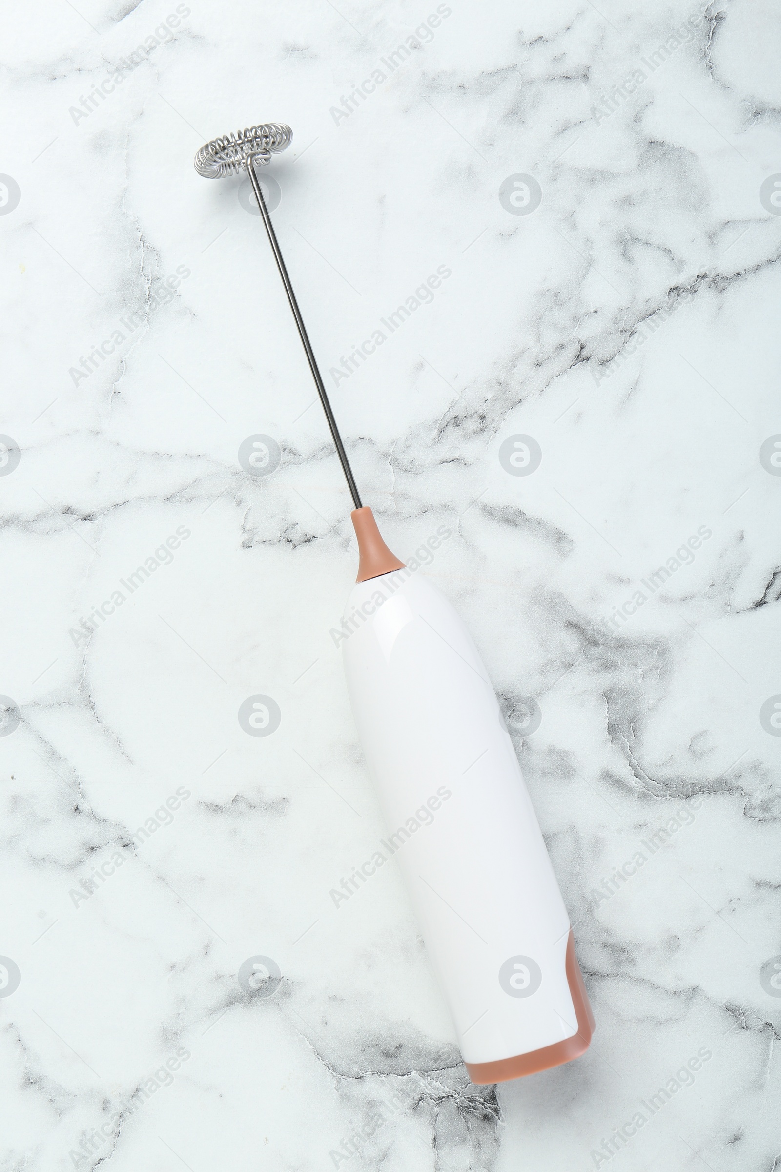 Photo of Milk frother wand on white marble table, top view