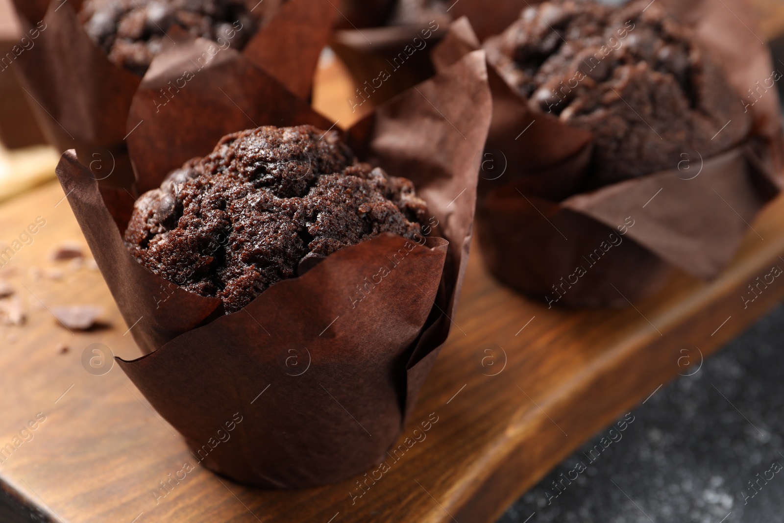 Photo of Tasty chocolate muffins on grey table, closeup