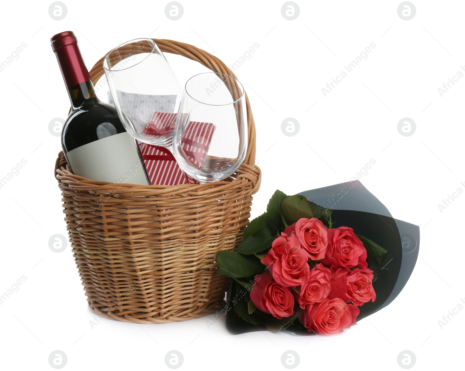 Photo of Wicker basket with presents near bouquet on white background