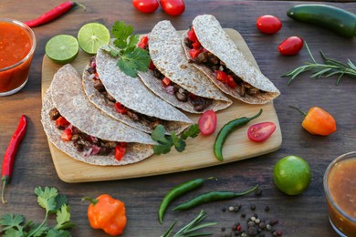 Delicious tacos with meat and vegetables on wooden table
