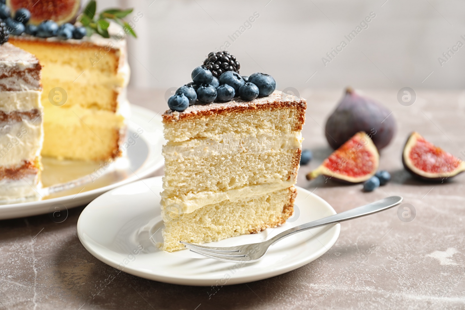 Photo of Piece of delicious homemade cake with fresh berries served on table