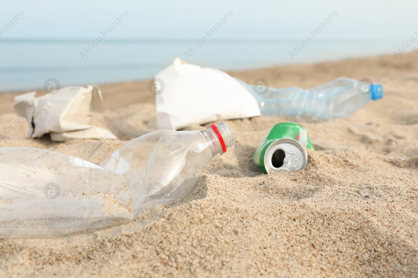 Photo of Garbage scattered on beach near sea, closeup. Recycling problem