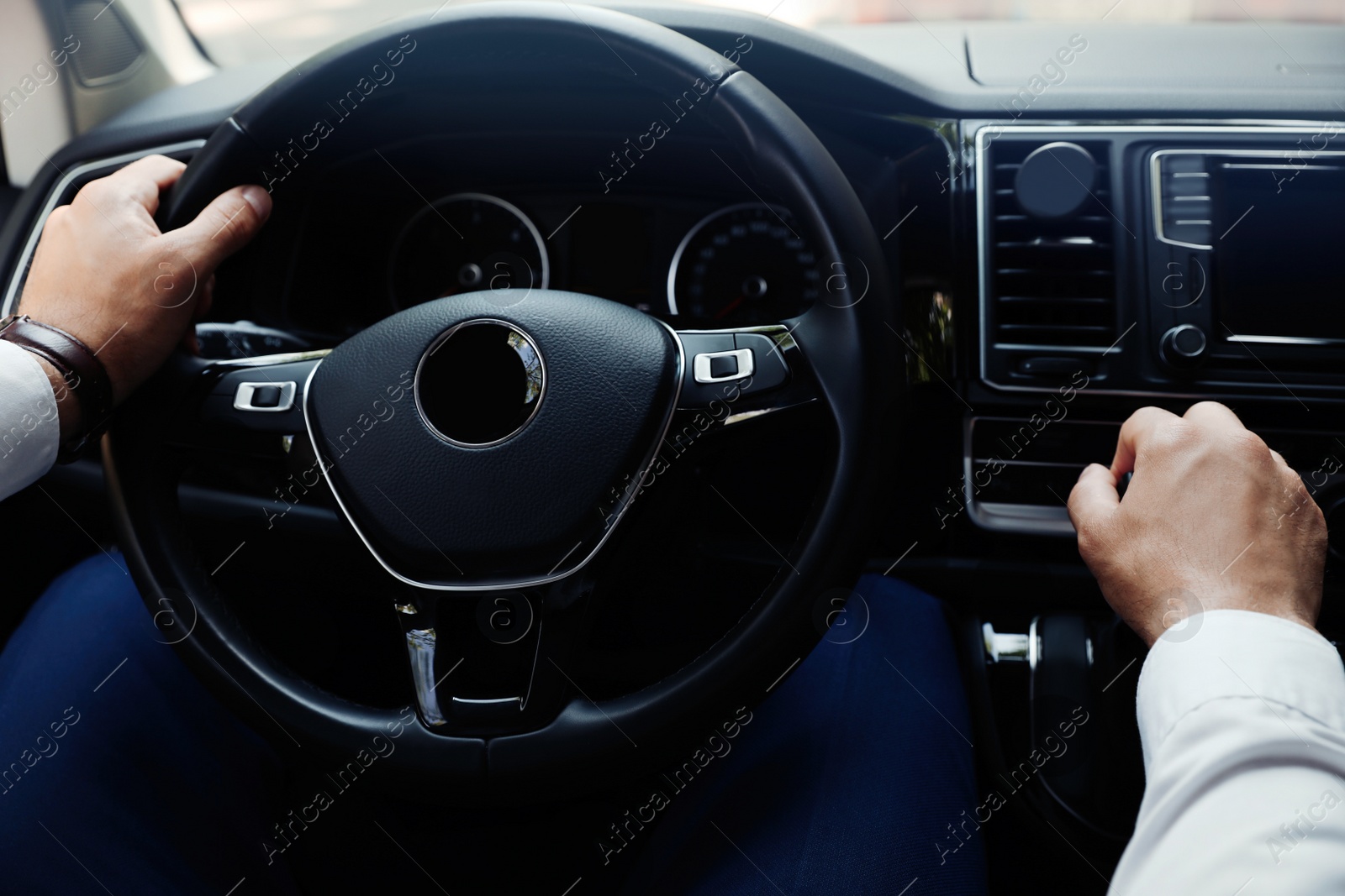 Photo of Man driving his car, closeup view of hands on steering wheel