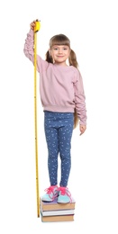 Photo of Little girl measuring her height on white background