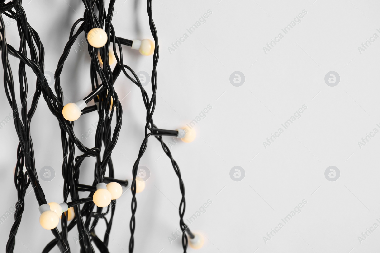 Photo of Beautiful Christmas lights on white background, top view