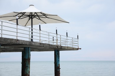Photo of Beautiful view of pier with sun umbrellas near sea