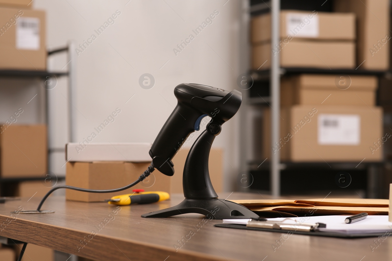 Photo of Black modern barcode scanner on wooden table in office. Online store