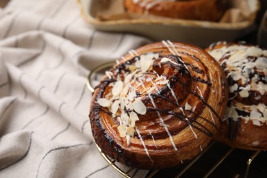 Photo of Sweet buns. Delicious rolls with toppings and almond on cloth, closeup. Space for text