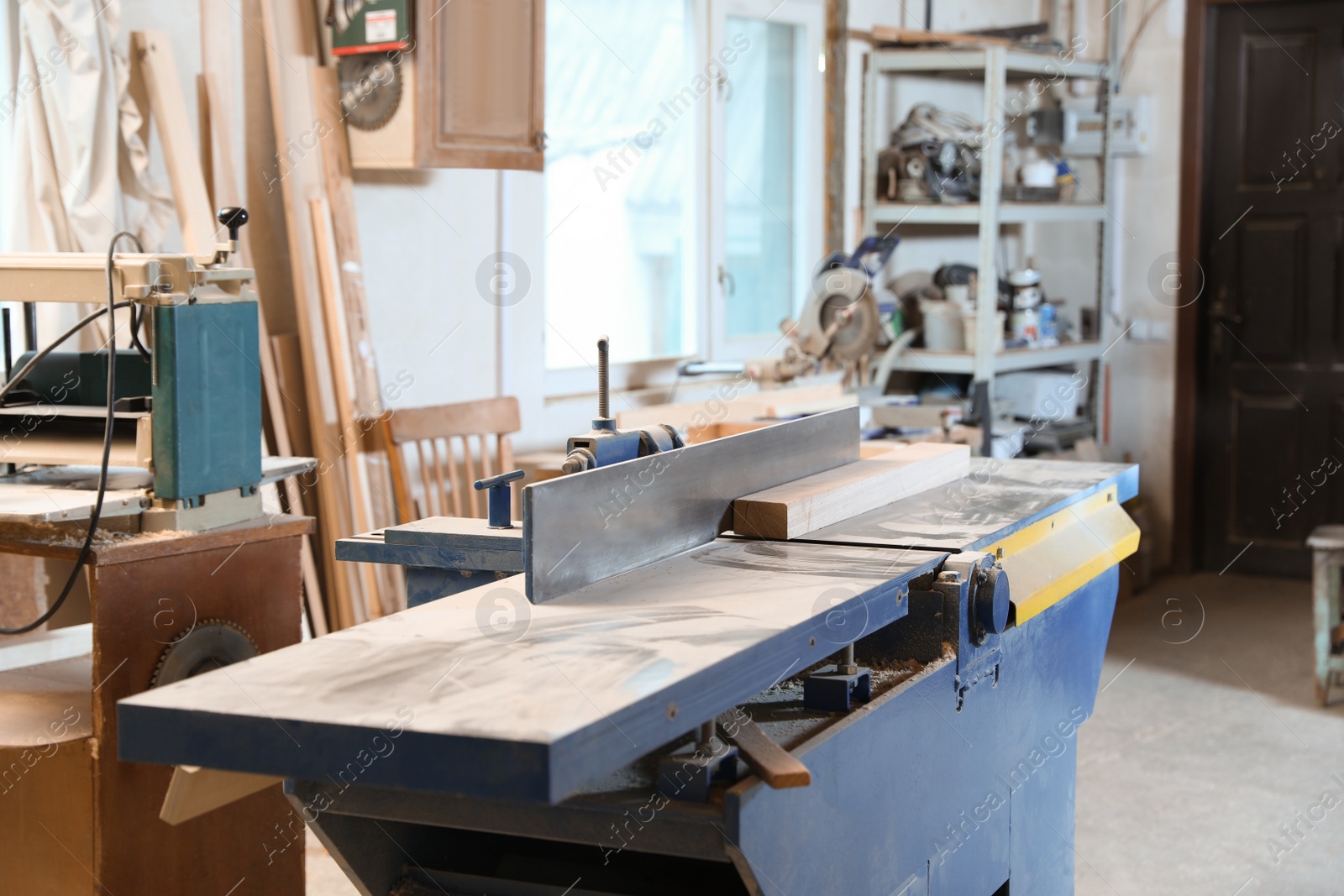 Photo of Modern wood machines in carpentry shop. Working space