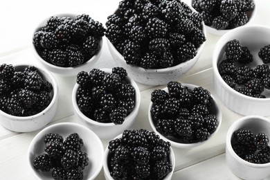 Photo of Ripe blackberries on white wooden table, closeup