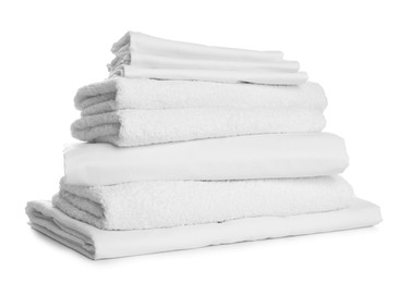 Stack of towels and bed sheets on white background