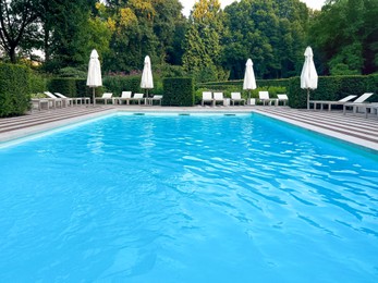 Photo of Outdoor swimming pool in luxury hotel on sunny summer day. Time for relax