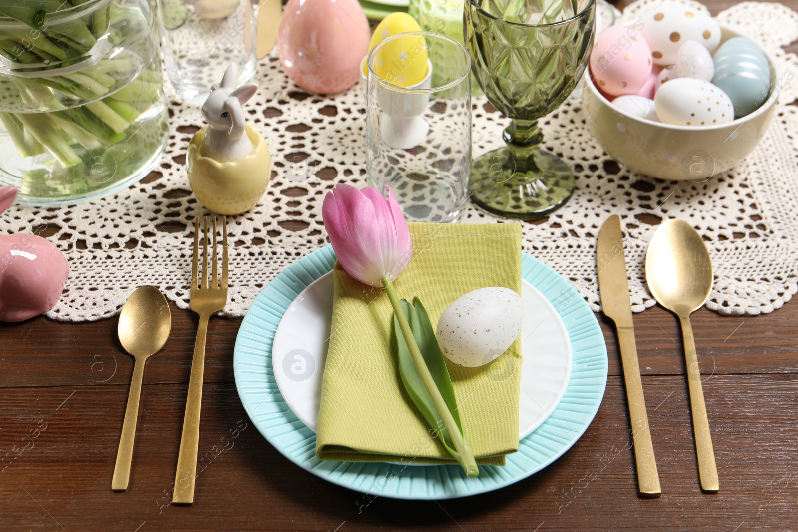 Photo of Festive table setting with painted eggs. Easter celebration