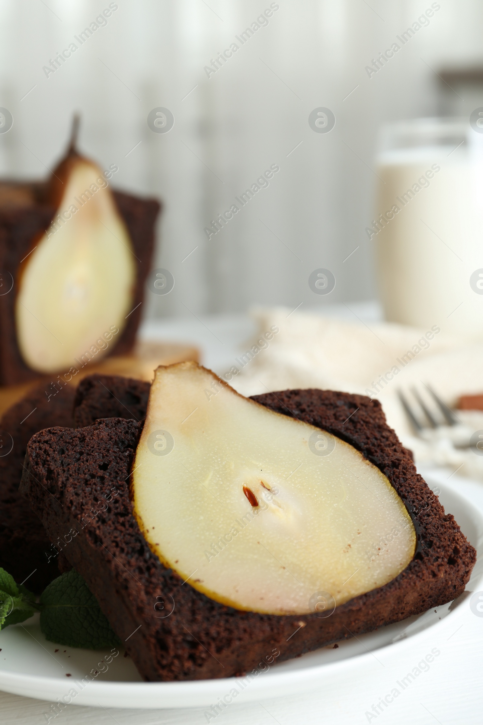 Photo of Tasty pear bread served with mint on white wooden table. Homemade cake