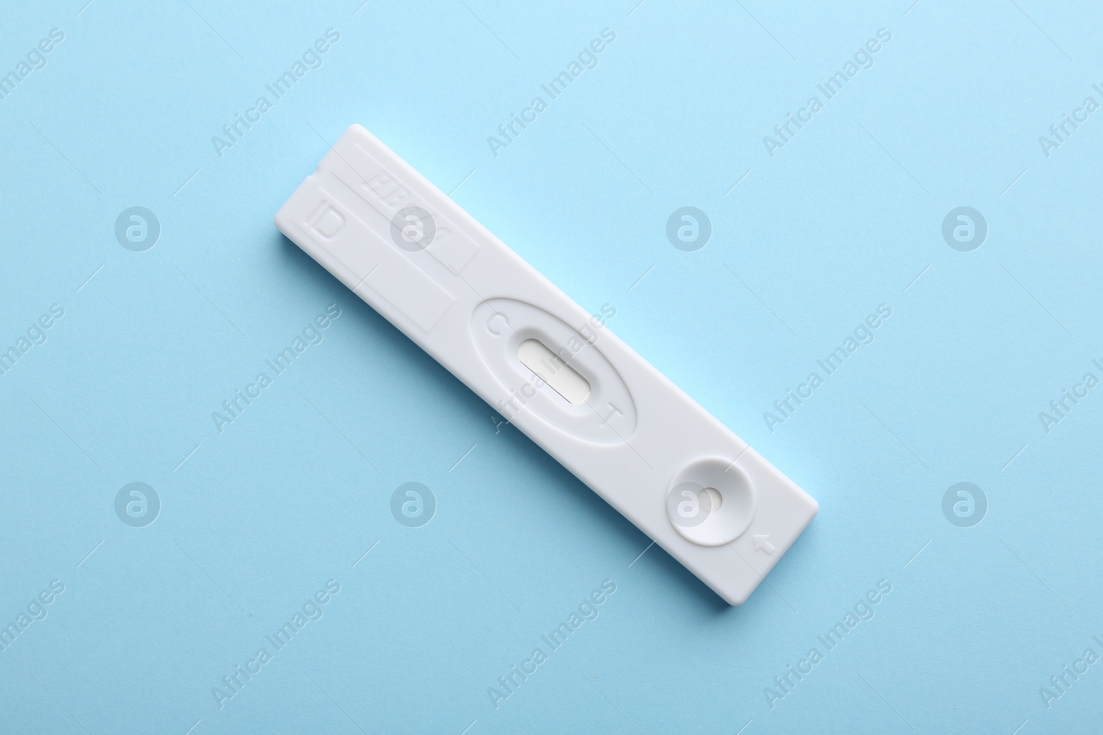 Photo of Disposable express test on light blue background, top view