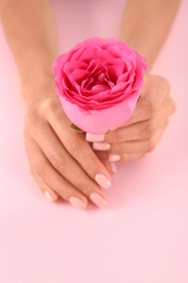 Closeup view of woman with rose on color background. Spa treatment