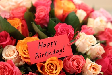 Image of Bouquet of beautiful roses with Happy Birthday card, closeup