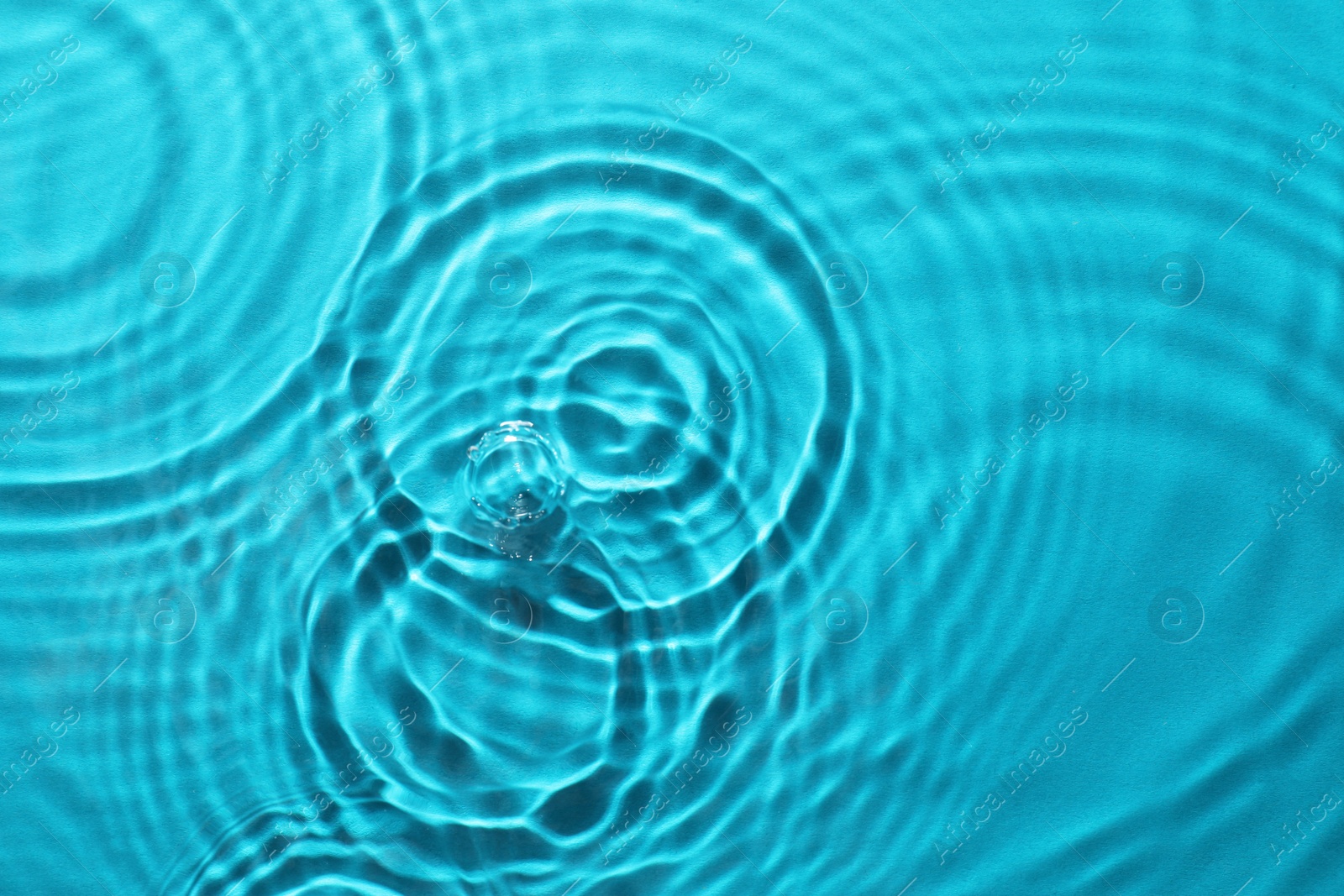 Image of Rippled surface of clear water on light blue background, top view