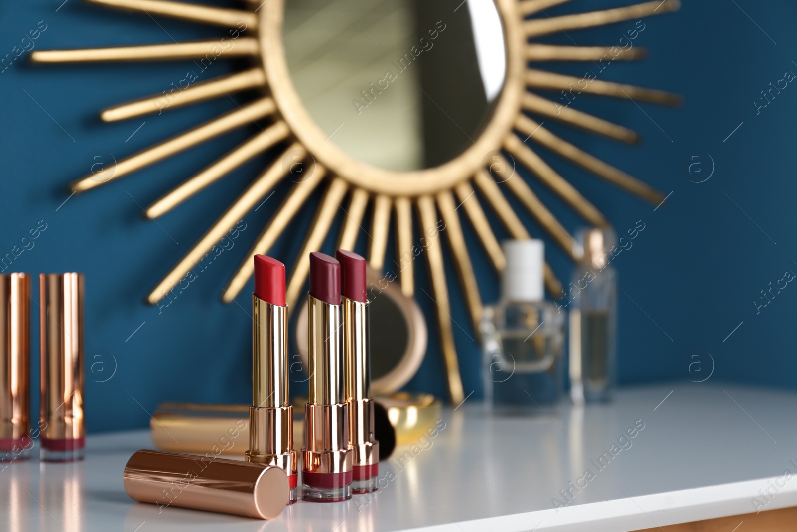 Photo of Open bright lipsticks on dressing table, space for text