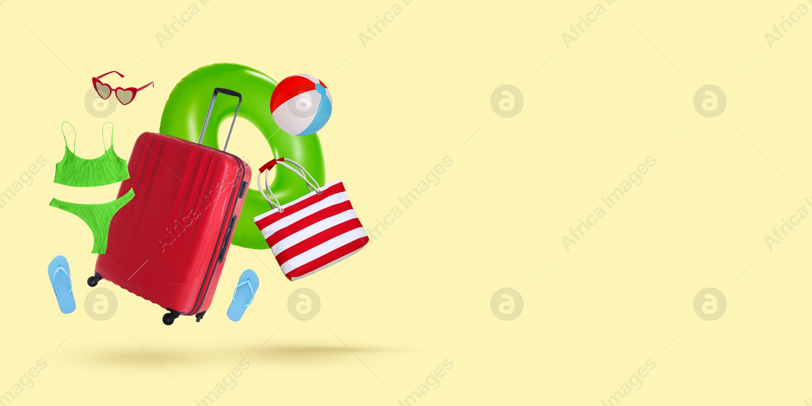 Image of Red suitcase and beach accessories flying on beige background. Banner design with space for text