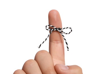 Photo of Man showing index finger with tied striped bow as reminder on white background, closeup