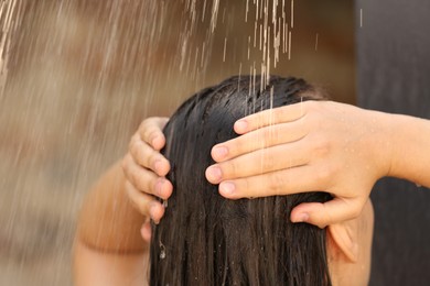 Photo of Woman washing hair in outdoor shower on summer day, closeup