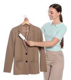 Young woman cleaning suit with lint roller on white background