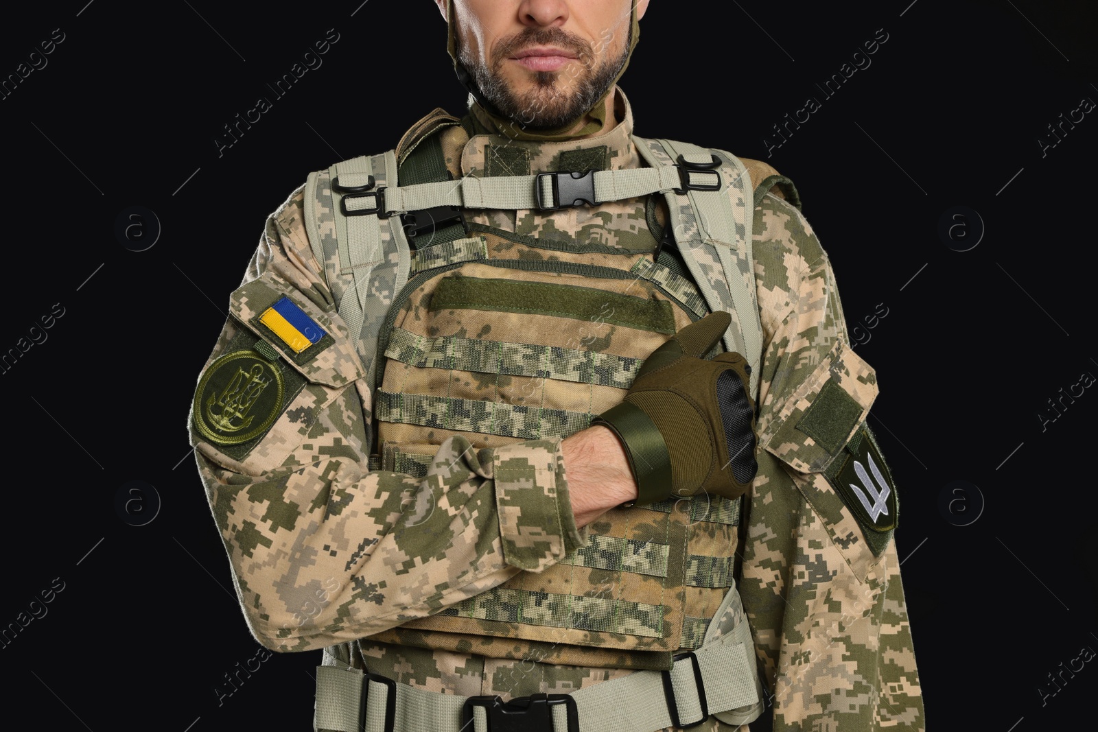 Photo of Soldier in Ukrainian military uniform on black background, closeup